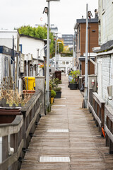 Obraz premium Narrow empty street between small wooden houses by the water, calm riverside view from side perspective