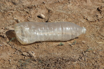 A plastic bottle lying on the ground, Plastic pollution, Plastic environmental impact