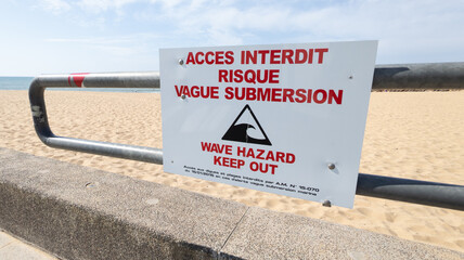 warning sign on the beach in french text acces interdit risque vague submersion signage panel means...