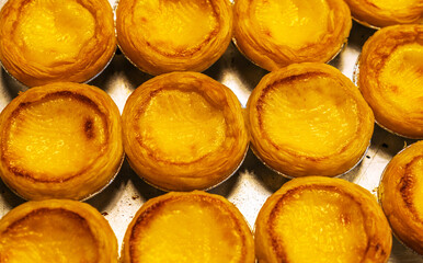 Egg tarts in cups, arranged in bright, appetizing colors.