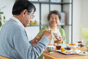家で朝食を食べるシニアの夫婦