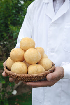Hand holding basket of pani puri golgappa Indian street food puffs in wicker basket outdoors