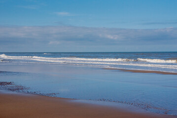 Sunny day with clouds on the Dutch North Sea coast. Vacation at the beach.
