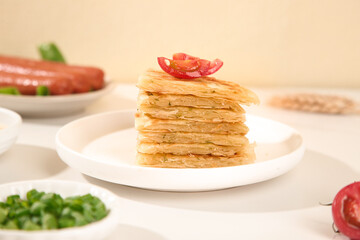 Shanghai Scallion Pancakes Stack with Chili Garnish - Traditional Chinese Pan-Fried Flatbread on White Plate