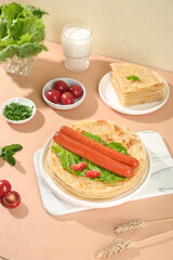 Handmade crispy layered flapjacks with sausages and fresh vegetables healthy breakfast meal on wooden table