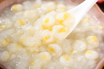 White sticky corn kernels with wooden spoon in soup preparation