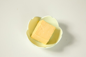 Fresh Butter Block in White Bowl on Clean Background