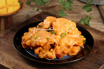 Crispy Golden Glazed Pork Dish on Black Plate with Chopsticks Asian Cuisine Food Photography