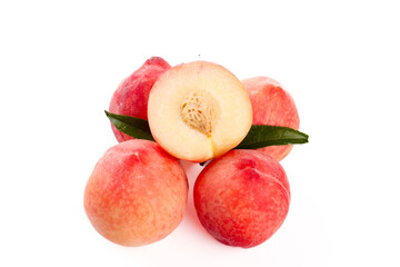Fresh Ripe Peaches Cut in Half with Green Leaves on White Background