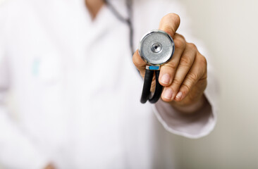 Close-up shot of a doctor extending a stethoscope, emphasizing healthcare, examination, and medical...