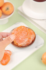 Candied dried persimmon fruit slice held in hand, traditional Asian sweet snack on white plates