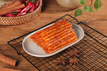 Handmade Spicy Chili Sticks Crispy Asian Snack Food on Wooden Background with Red Peppers and Star Anise