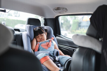 Cute little Asian girl sleeping in car seat inside car during travel,A young child girl 2-3 years sleeping peacefully in a car seat during a car ride.