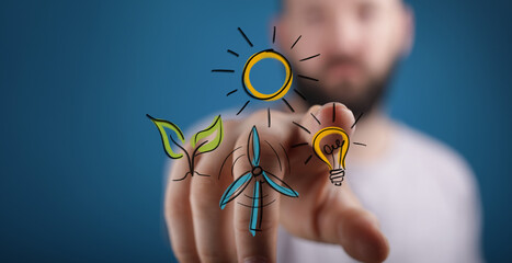 Stock photo of a man interacting with renewable energy icons: sun, wind turbine, plant, lightbulb. Concept of sustainability and innovatio