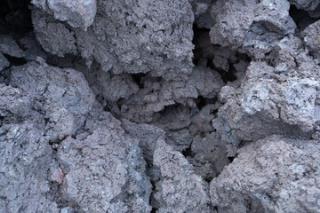 Textured surface of volcanic ash and rock debris, showcasing a rugged, natural landscape with earthy tones and intricate details, ideal for environmental and geological themes