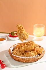 Crispy Fried Chicken Nuggets in Basket with Sauce and Drink on Orange Background