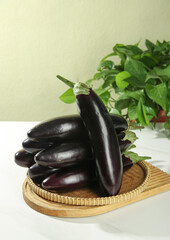 Fresh Purple Eggplants in Wicker Basket with Basil Herbs for Healthy Cooking