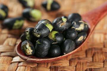 Fresh Black Beans with Green Sprouts in Wooden Spoon on Rustic Wood Background
