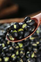 Crispy Fried Black Beans with Green Hearts in Wooden Spoon - Traditional Asian Snack Food with Salt and Spices