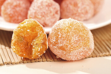 Sugar Coated Dried Kumquat Fruit Candies on Bamboo Mat - Traditional Asian Sweet Snack Food