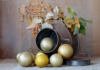 A metal pot with  Christmas balls and dry oak branch