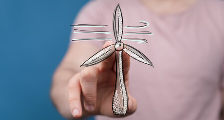 Image of a hand interacting with a wind turbine sketch, representing clean energy, sustainability,...