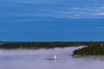 Inseln im Schärengarten mit Nebel und Leuchtfeuer vor Stockholm, Schweden