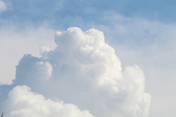 Fluffy white clouds floating under blue sky