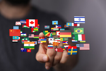 A hand reaching towards various national flags, representing globalization, travel, and the concept...