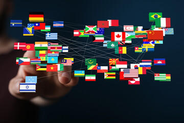 A hand touching a network of country flags. Representing global interconnectedness, international relations, and travel. Suitable for themes of