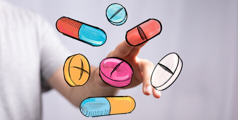 Stock photo of hand interacting with colorful drawn pills and capsules.  Perfect for healthcare, medicine, pharmacy, and wellness.