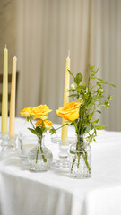 wedding arrangement for the bride and groom's table. A small bouquet of yellow roses and yellow candles