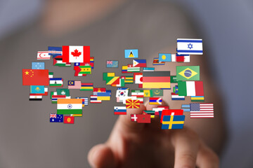 A hand reaching toward a collection of flags from different nations, symbolizing global...