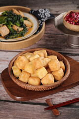 Delicious fried tofu puffs and traditional Asian dishes on wooden table with chopsticks