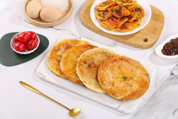 Pan-Fried Scallion Fritters with Fresh Ingredients and Pasta on Marble Kitchen Counter