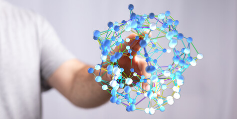 A person's hand interacting with a digital representation of a network or molecular structure. Depicting data connection, communication, and fut
