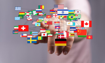 A person's hand interacts with a network of interconnected national flags, representing global...