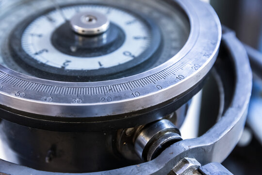 A detailed close-up of a circular dial gauge of a gyrocompass