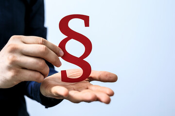 Hand holding red paragraph symbol. Law, justice, legal concept. Stock photo.