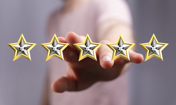 Close-up shot of a person's hand extending towards five golden stars. Concept of appreciation, feedback, or quality, representing rating and cus
