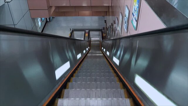POV of riding an empty descending escalator in the MTR station, subway station with no people