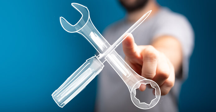 High-quality image of a man's hand pointing at a virtual wrench and screwdriver, symbolizing repair, solution, and maintenance.