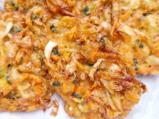 Delicious Bakwan Sayur, crispy vegetable fritters with cabbage, carrots, and bean sprouts, freshly fried.