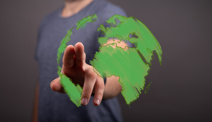 Human hand interacts with a vibrant green digital Earth, symbolizing global environmental...