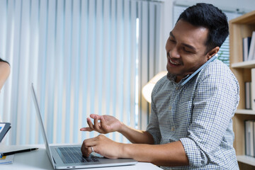 A woman and a man are talking in front of a white board with a picture on it. The woman is pointing at the picture and the man is looking at her
