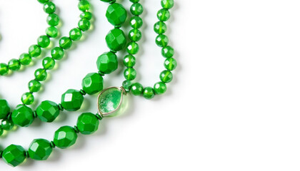 Obraz premium Green beaded necklaces arranged on white background for Saint Patrick's Day copyspacec