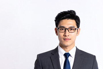 A businessman with black hair and glasses wearing a suit