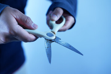 A man holds scissors with both hands, ready to cut something.