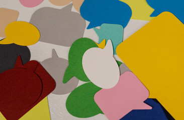 A vibrant, colorful collection of speech bubbles, representing communication, ideas, and discussions, arranged on a bright white surface. Perfec