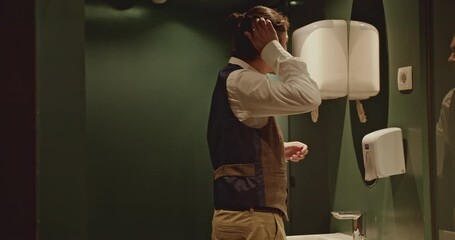 A businessman dries his hands in an office bathroom. Startup business international.